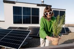 femme sur son toit entourée de panneaux photovoltaïques