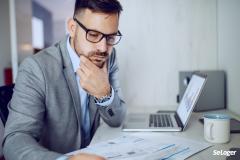 Un homme qui regarde les documents d'une SCI