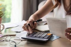 Une femme calcule si son salaire couvre trois mensualités de loyers