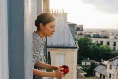 Une femme à la fenêtre de son appartement parisien