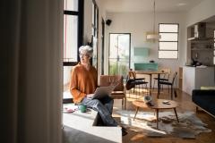 Femme assise au bord de la fenêtre de son salon