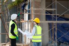 une femme et un homme de dos en tenue de chantier