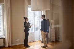 Une jeune femme avec un couple visitent une maison