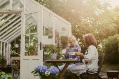 deux femmes assises à une table dans le jardin