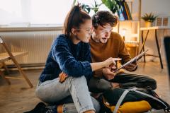 Un jeune couple en train de regarder une tablette 