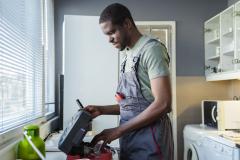 plombier en train de travailler dans cuisine