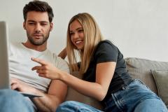 Jeune couple en train de regarder un ordinateur