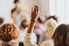 assemblée avec une main levée