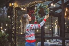 Une femme décorant l'extérieur de sa maison pour noël