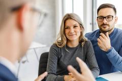 Un couple échange avec son banquier, assis devant un bureau