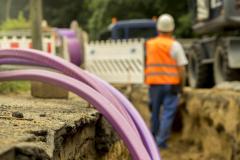 Un employé d'une société de BTP travaille sur un chantier de raccordement pour lequel la route a dû être coupée