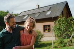 Un couple enlacé se tient devant sa maison bioclimatique