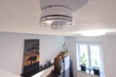 Un détecteur de fumée est fixé au plafond dans une pièce de vie