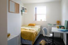 Petite chambre coquette pour un étudiant, avec un coin nuit, un coin bureau et un lavabo