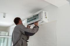 Professionnel qui installe une climatisation