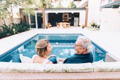 couple de retraités devant la piscine de leur résidence secondaire