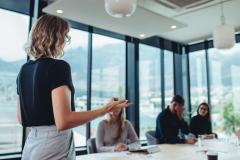 Femme au bureau, animant une réunion avec ses collègues. 