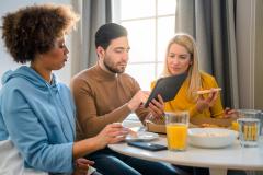 Colocataires lisant sur une tablette pendant le petit déjeuner. 