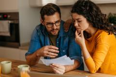 Un couple découvre inquiet le contenu d'un courrier recommandé dans sa cuisine