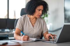 Une femme d'origine hispanique travaille sur son ordinateur portable dans son bureau