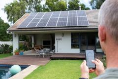 Un homme utilise une application mobile pour contrôler son système d’énergie solaire