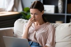 jeune femme assise sur son canapé se renseigne sur la possibilité de faire plusieurs offres d'achat sur un même bien 