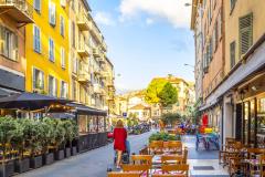 Une femme avec une poussette se promène dans une rue du Vieux Nice