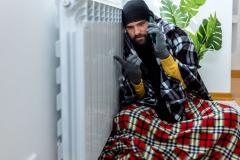 homme-emmitouflé-dans-ses-couvertures-appelle-pour faire dépanner son radiateur
