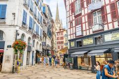 Touristes marchant dans une rue commerçante du centre de Bayonne, France