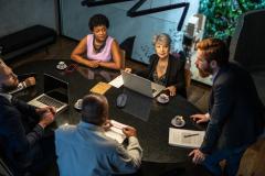 Des personnes échangent autour d'une table lors d'une assemblée générale de copropriété