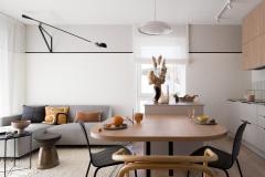 Joli salon avec canapé d'angle gris et table en bois au premier plan. 