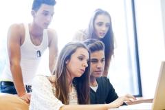 Un groupe de 4 étudiants effectue une recherche sur un ordinateur