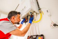 Un technicien assure la réparation d'une chaudière à gaz dans un logement