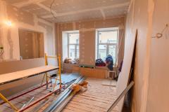 Maison en chantier avec planches de bois posées sur le mur et au sol. 