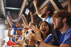 Des supporters de foot français s'enthousiasment devant un match de leur équipe diffusé dans un pub