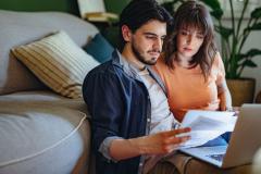 Couple comparant des offres d'assurance emprunteur en ligne.