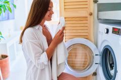 Une femme sort du linge propre de son lave-linge