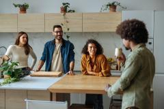 Colocataires en discussion dans la cuisine couleur bois clair et blanc