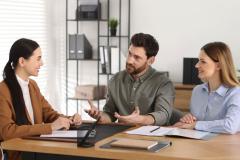 Couple signe l'acte de vente chez le notaire.