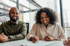 Couple signant un contrat de vente.