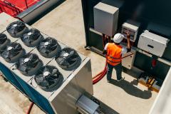 Un technicien travaille sur le système de climatisation sur le toit d'un immeuble