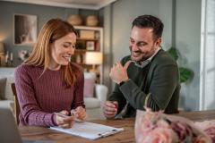 Couple d'acquéreurs signant l'acte de vente d'un bien immobilier.