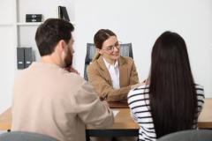 Couple signant l'acte de vente chez le notaire. 
