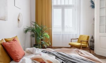 Chambre à coucher avec lit au premier plan et rideaux jaunes