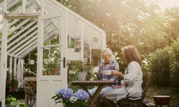 deux femmes assises à une table dans le jardin