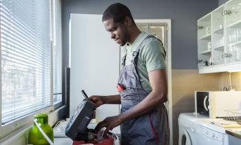 plombier en train de travailler dans cuisine