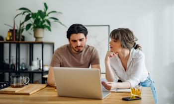 Couple s'interroge quant à l'amélioration de leur DPE devant leur ordinateur