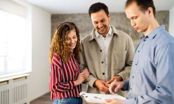 Un professionnel donne des explications sur un document à un couple