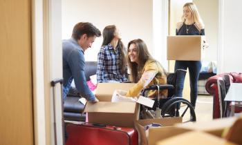 Groupe de jeunes étudiants emménageant en colocation dans un nouvel appartement