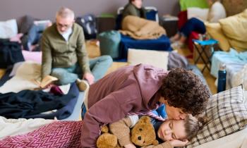 Un groupe de plusieurs personnes dorment sur des lits de fortune dans une seule et même pièce